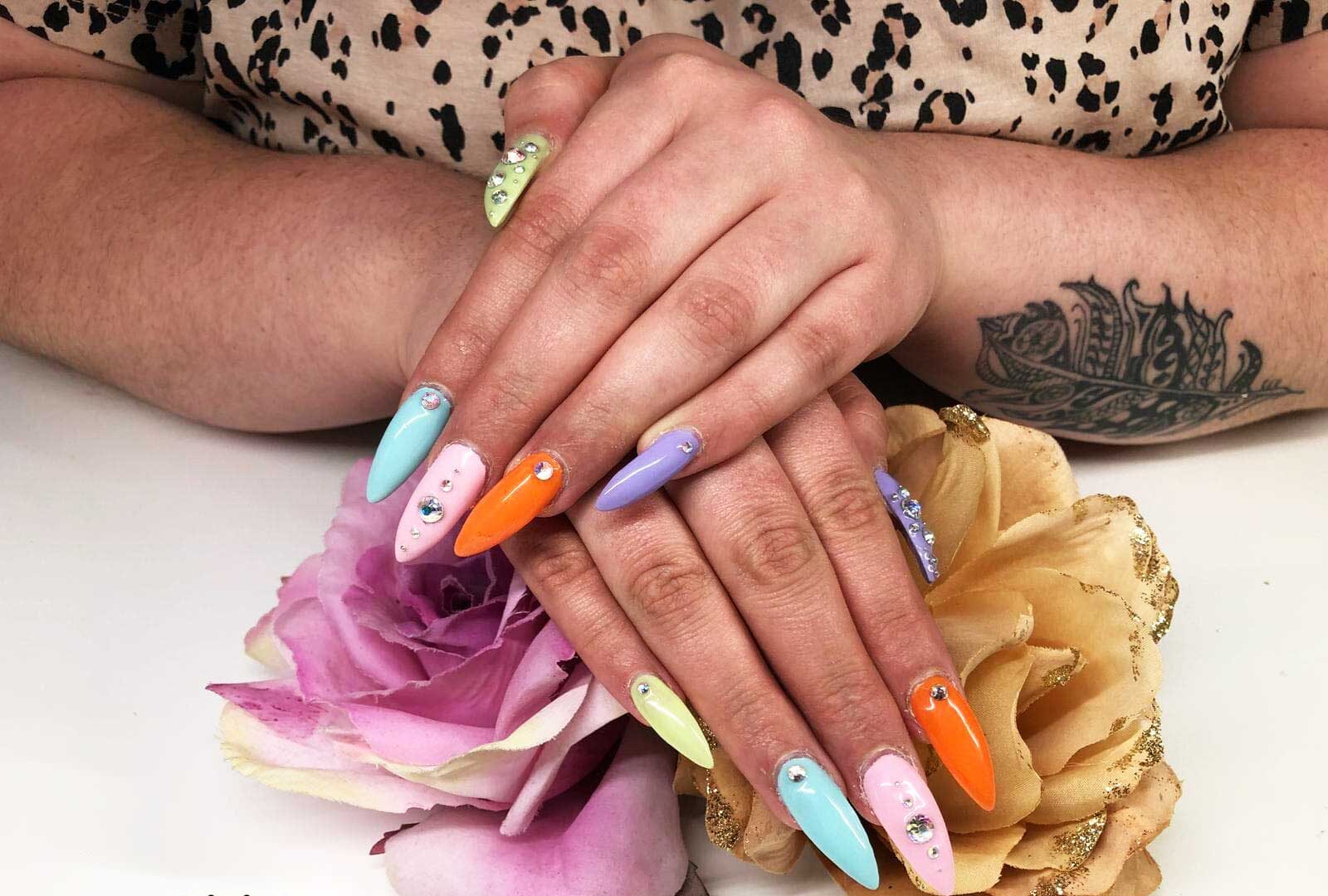 Lange amandelvormige kunstnagels in pastelkleuren met steentjes