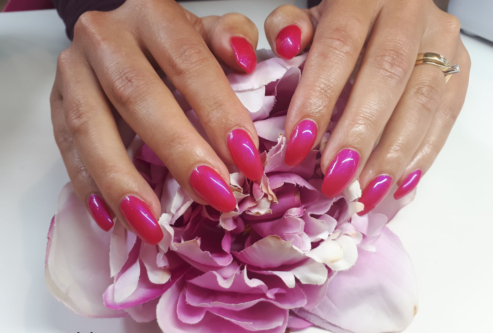 Roze glanzende nagels op een pioenroos